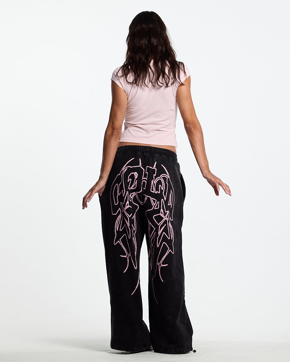 55 SWEATPANTS BLACK - washed black graphic sweatpants, back view on female model - Cold Culture