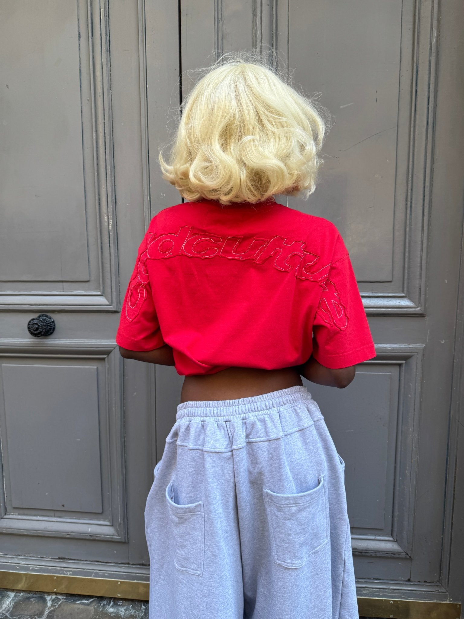 DISTRESS CURVED TEE RED - red distressed tee, back view on female model - Cold Culture